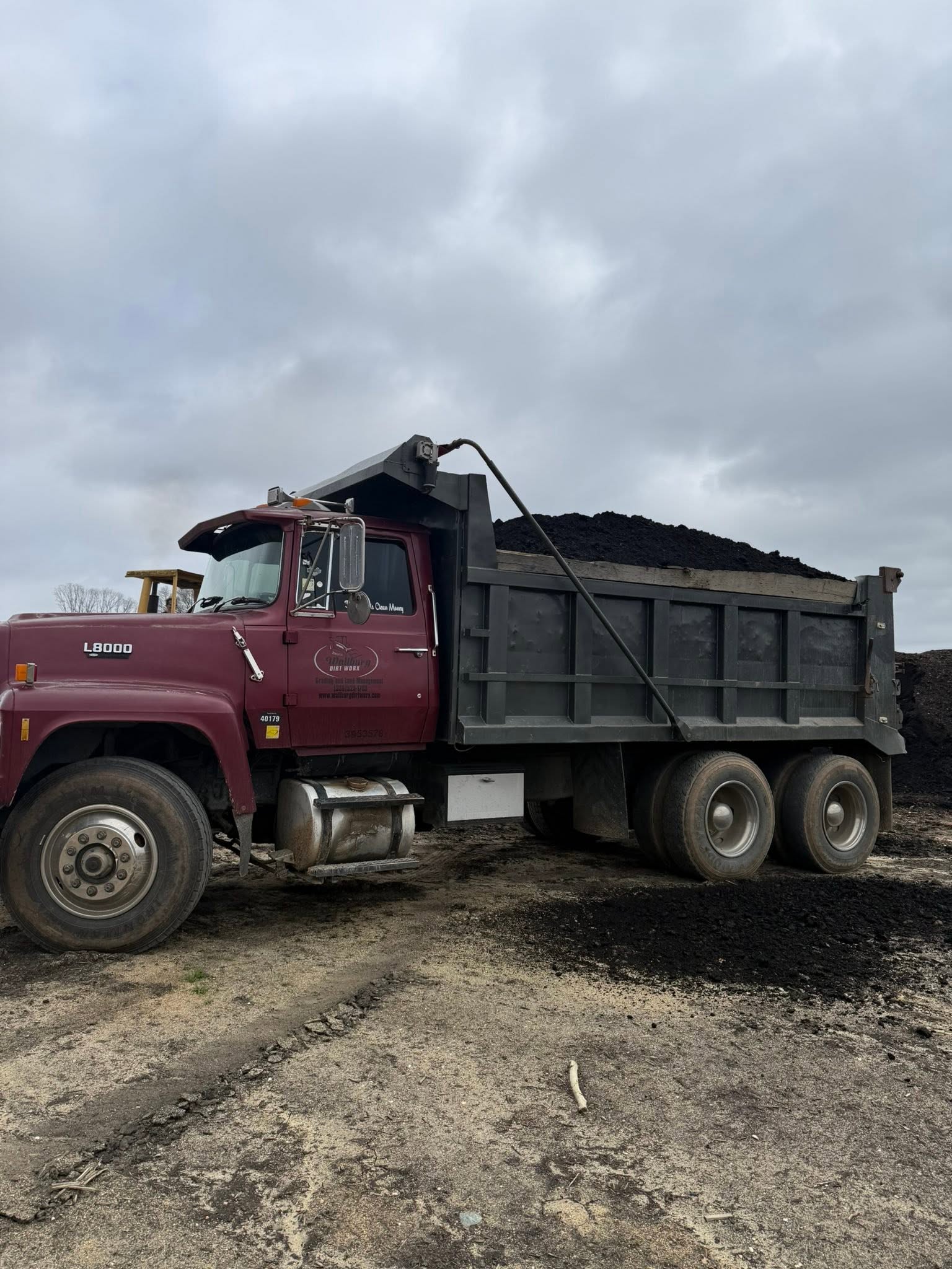 Dump truck loaded with black mulch ready to leave the Wallburg Mulch Worx yard
